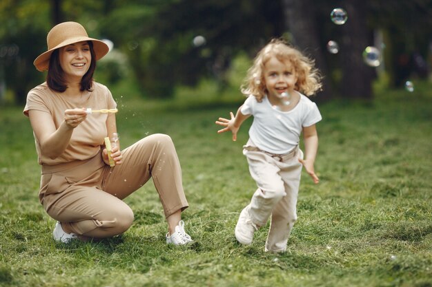 Elegante madre con figlia in una foresta estiva