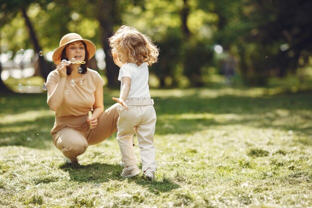 Elegante madre con figlia in una foresta estiva