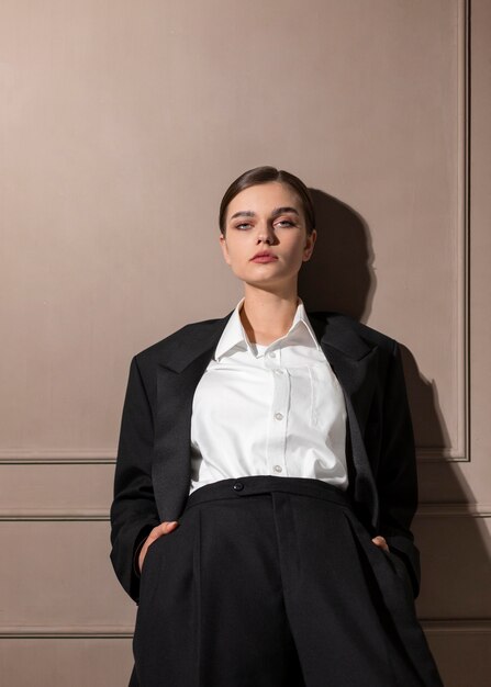 Elegante modello femminile in posa in studio in giacca e cravatta. nuovo concetto di femminilità
