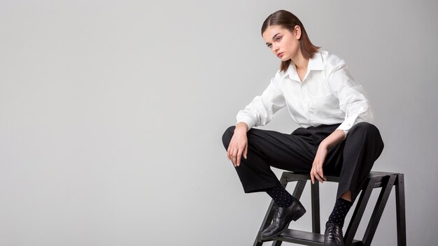Elegante modello femminile in posa per le scale in un abito giacca. nuovo concetto di femminilità