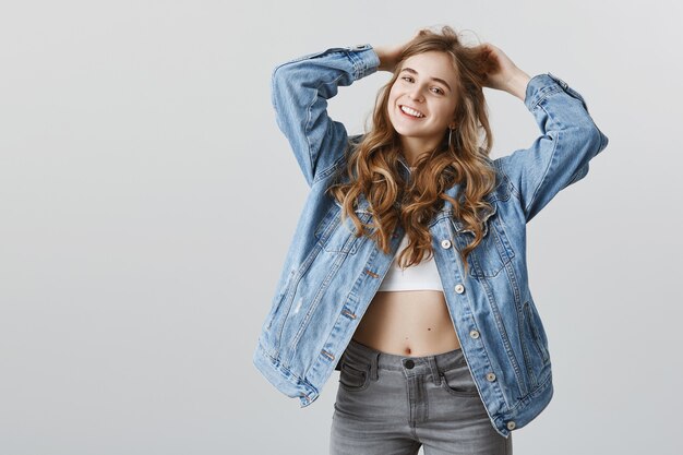 Elegante ragazza bionda attraente felice che fa taglio di capelli, sorridente