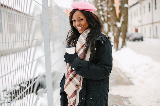 Elegante ragazza nera in una città d&#39;inverno