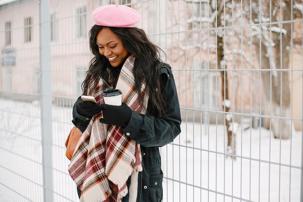 Elegante ragazza nera in una città d&#39;inverno