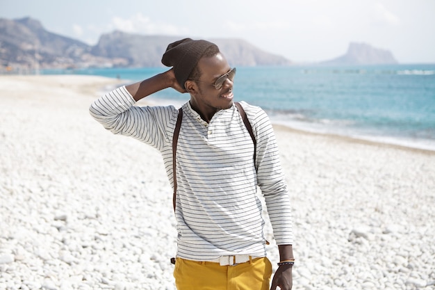 Elegante uomo afro-americano sulla spiaggia