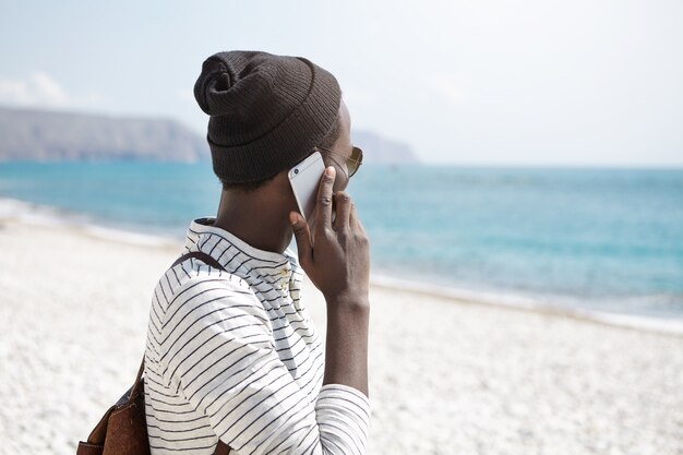 Elegante uomo afro-americano sulla spiaggia