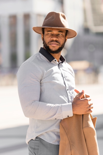 Elegante uomo afroamericano in posa mentre distoglie lo sguardo