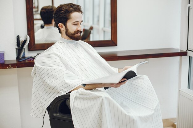 Elegante uomo seduto in un negozio di barbiere