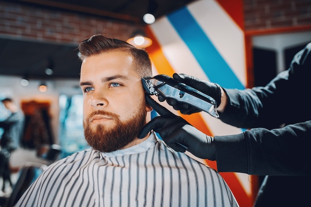 Elegante uomo seduto in un negozio di barbiere