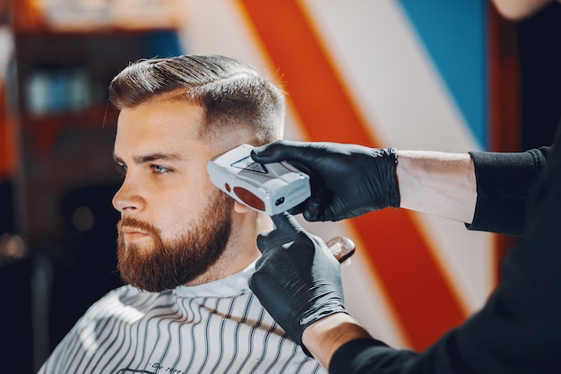 Elegante uomo seduto in un negozio di barbiere