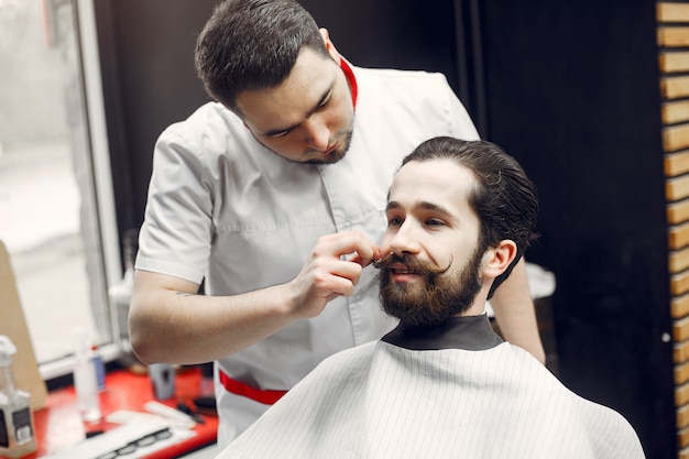 Elegante uomo seduto in un negozio di barbiere