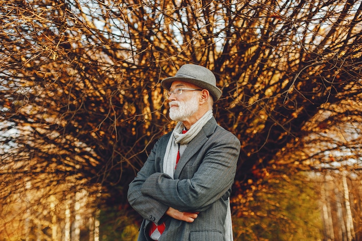 Foto gratuito elegante vecchio in un parco soleggiato autunno