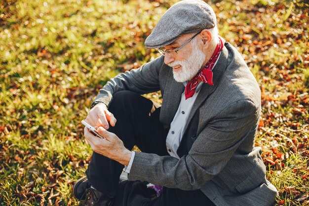 Elegante vecchio in un parco soleggiato autunno