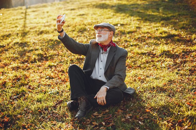 Elegante vecchio in un parco soleggiato autunno