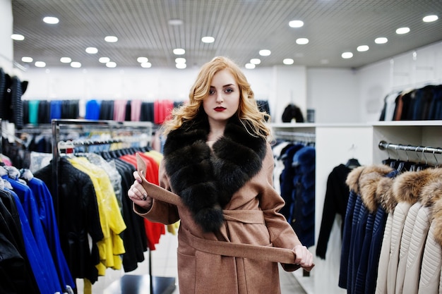 Eleganza ragazza bionda in pelliccia al negozio di pellicce e giacche di pelle