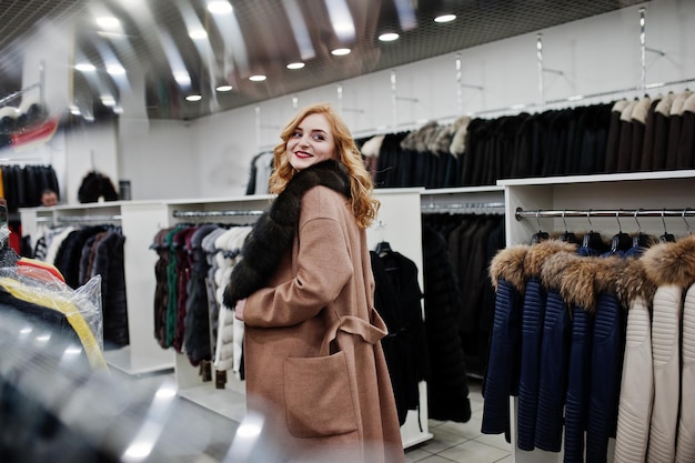 Eleganza ragazza bionda in pelliccia al negozio di pellicce e giacche di pelle