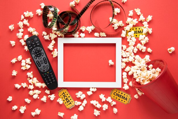 Elementi del cinema e cornice bianca su sfondo rosso