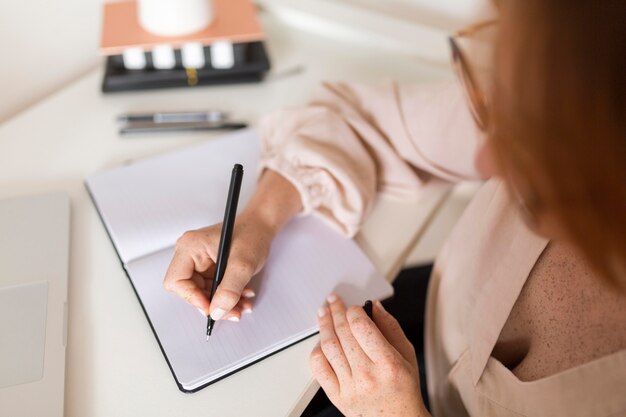 Elevato angolo di insegnante femminile alla scrivania durante la lezione online