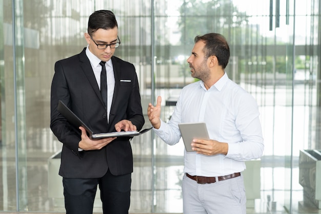 Emotional businessman with tablet dimostrando il suo punto