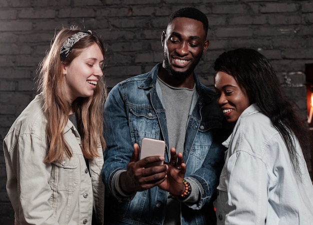 Entusiasti amici multirazziali guardando il telefono