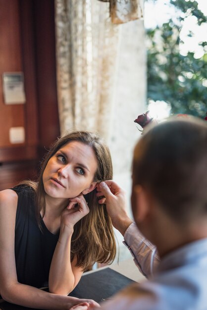 Equipaggi i capelli della tenuta della donna vicino alla finestra in caffè