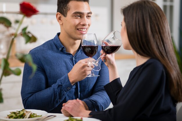 Equipaggi l'esame di sua moglie mentre tengono un bicchiere di vino