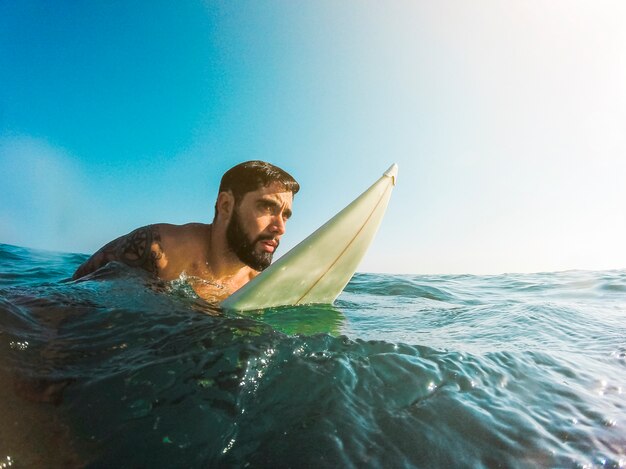 Equipaggi la condizione con il surf in acqua blu
