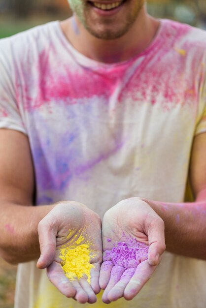 Equipaggi la pittura della polvere della tenuta in sue mani al holi