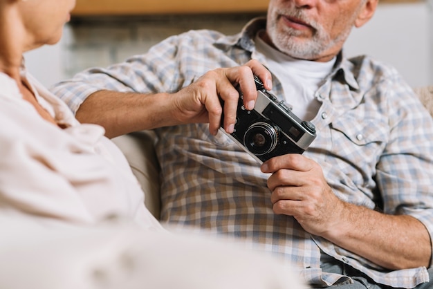 Equipaggi la seduta con la sua macchina fotografica della tenuta della moglie a disposizione