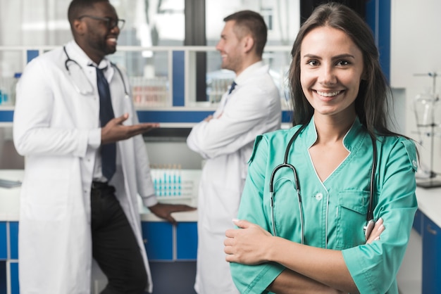 Erba medica sorridente della donna con le armi attraversate