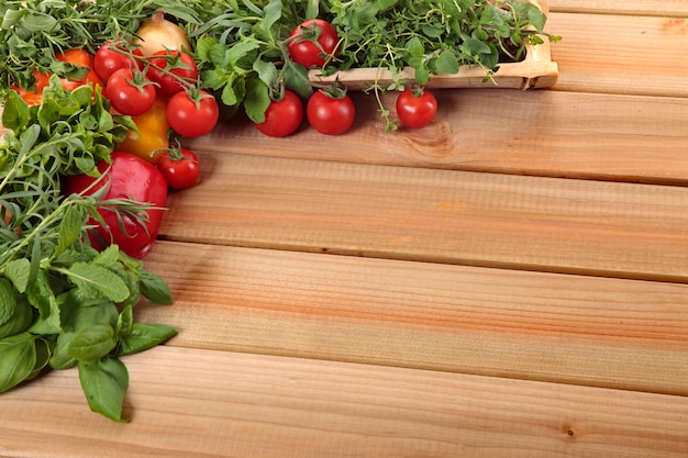 Erbe e verdure con una tavola di legno