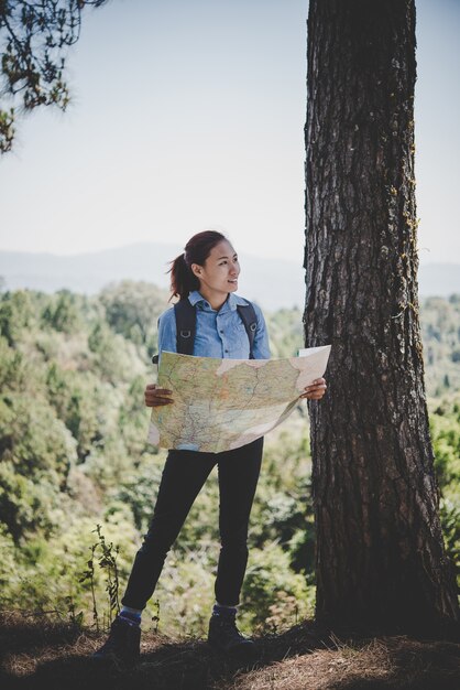 Escursionista backpacker giovane donna che legge mappa di viaggio trekking. Rilassarsi in vacanza.