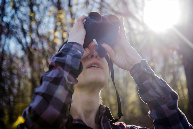 Escursionista con binocolo in una giornata di sole