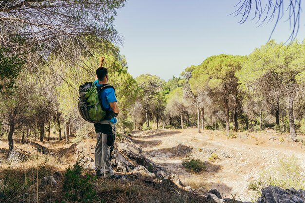 Escursionista con zaino in piedi nella foresta