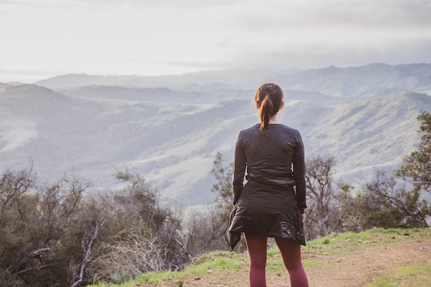 Escursionista femmina in piedi sulla sommità del sentiero escursionistico Gaviota Peak catturato in California, USA