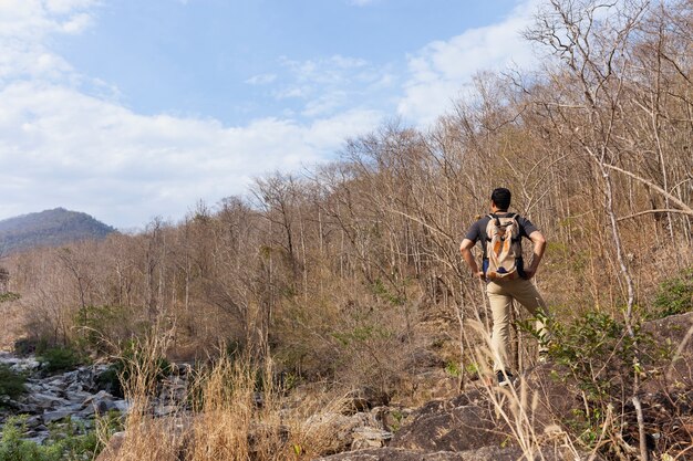 Escursionista in piedi sulla collina vicino al fiume