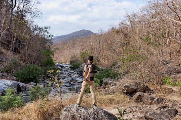 Escursionista in piedi sulla pietra davanti fiume