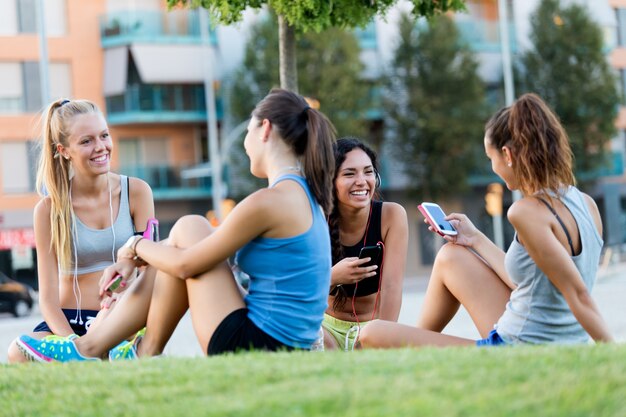 Esecuzione di ragazze divertirsi nel parco con il cellulare.