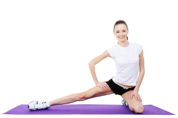 Esercizi fisici femminili sul pavimento - isolati su bianco