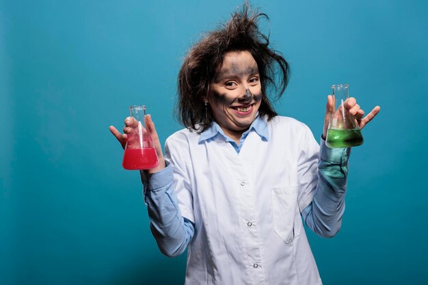 Esperto di chimica pazza dall'aspetto sciocco con i capelli disordinati che reggono boccette di vetro piene di composti chimici tossici. Chimico pazzo che si comporta da muto pur avendo bicchieri di vetro pieni di sostanze liquide.