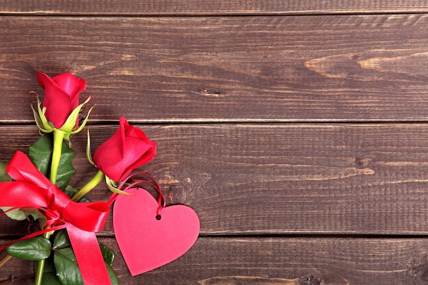 etichetta regalo di San Valentino e rose rosse su tavola di legno