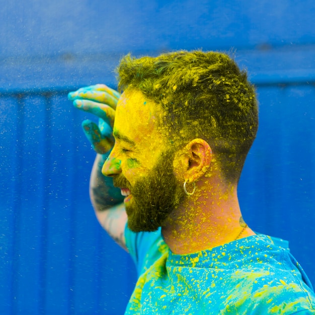 Faccia colorata di uomo felice sul festival di Holi