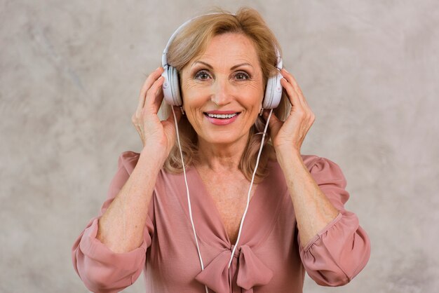 Faccina bionda signora ascoltando musica sul set di cuffie