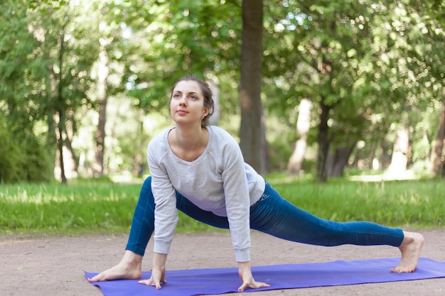 Facile variazione di posa di yoga di lucertola nel vicolo del parco