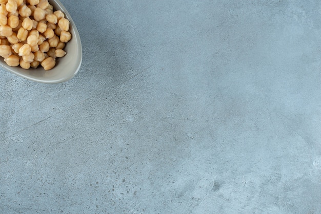 Fagioli bolliti in una tazza su sfondo blu. Foto di alta qualità