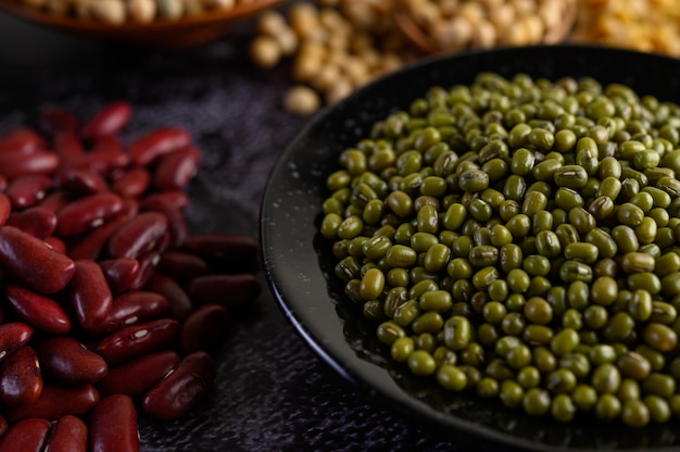 Fagiolo verde e fagiolo rosso su un pavimento di cemento nero.