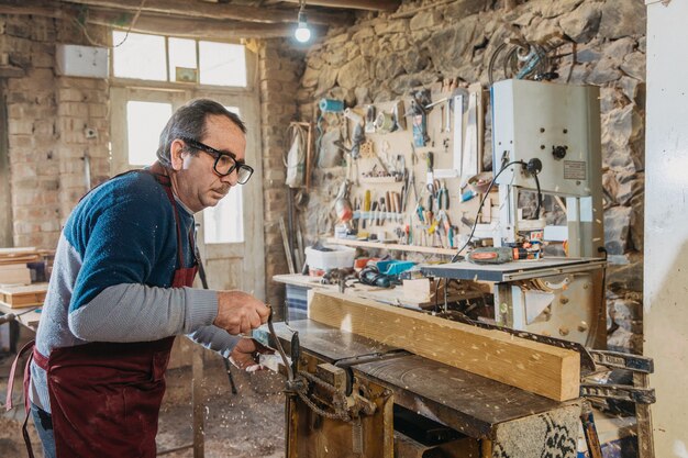 Falegname che utilizza il legno per realizzare sculture nell'atelier