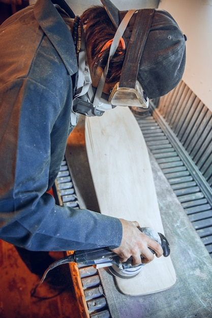 Falegname con sega circolare per il taglio di assi di legno. Dettagli costruttivi del lavoratore di sesso maschile o uomo a portata di mano con utensili elettrici