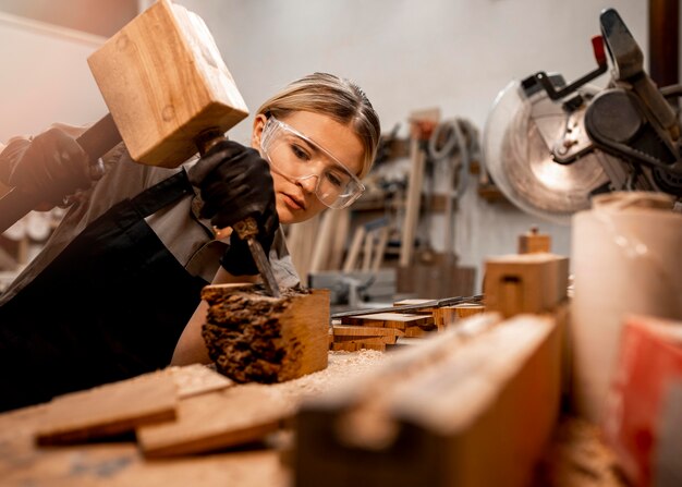 Falegname femminile in studio con strumenti per scolpire il legno