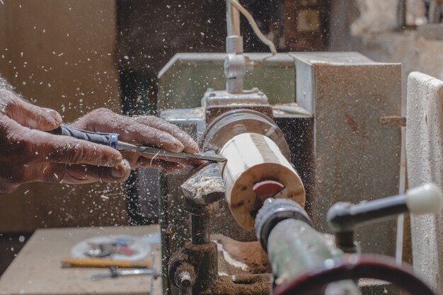 Falegname sbucciare pezzi di legno per fare figure