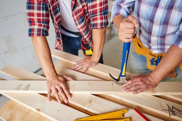 Falegnami che rimuovono i chiodi dal legno